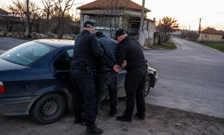 Полицейски служители при задържане на мъж край пътен кръстовище в село